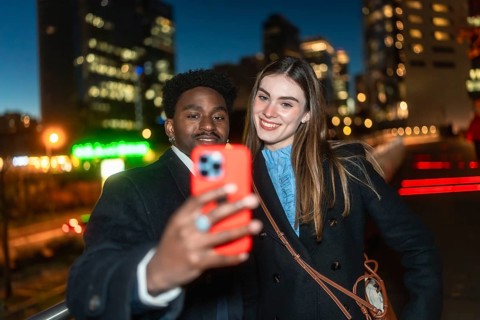 Diverse friends posing for a self portrait with a smartphone, smiling warmly as they enjoy a casual