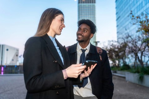 Two diverse business colleagues engaging in a discussion and sharing information on a digital