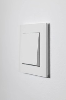 White light switch on a white wall, minimalistic design