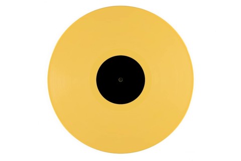 Yellow vinyl record with a black label in the middle on a white background