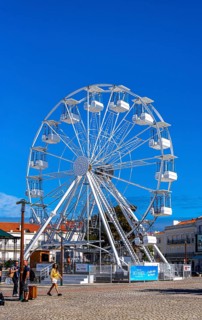 Ferris wheel next to the holy church Santuario de Nossa in Nazare, Portugal