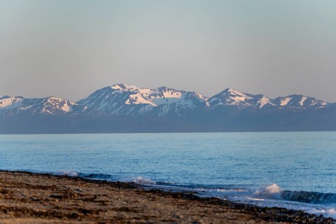 Anchor Point beach on Cook Inlet in the evening light, snowy mountain peaks of the Kenai Peninsula,