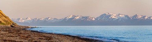 Boat on Anchor Point beach on Cook Inlet in the evening light, snowy mountain peaks of the Kenai