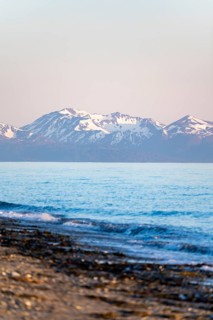 Anchor Point beach on Cook Inlet in the evening light, snowy mountain peaks of the Kenai Peninsula,