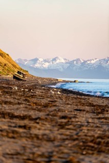 Boat on Anchor Point beach on Cook Inlet in the evening light, snowy mountain peaks, Anchor River