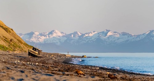 Boat on Anchor Point beach on Cook Inlet in the evening light, snowy mountain peaks, Anchor River