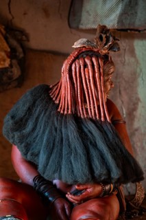 Elderly Himba woman showing her hair and jewelry, in a hut, traditional Himba village, Kaokoveld,