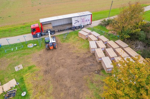 A forklift unloads boxes from a truck on a rural road, Bau PV Freifaechenanlage, Weil der Stadt,