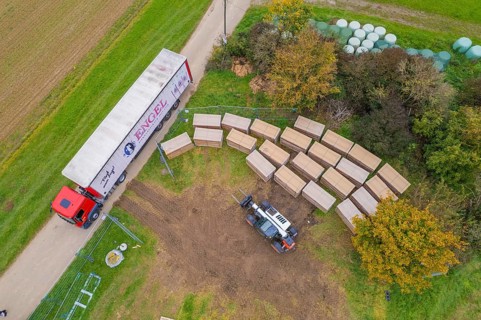 Aerial view of a forklift and truck in a colorful autumn landscape with boxes, construction PV