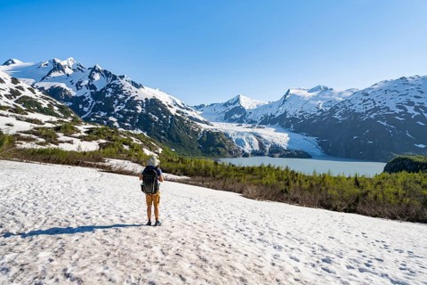 Hikers on a snowfield on the Portage Pass Trail, snowy mountains, Portage Glacier and Portage Lake,