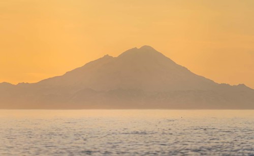 View of Cook Inlet on white mountain peaks of Mount Redoubt at sunset, midnight sun, Aleutian