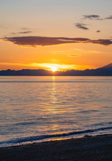 View of Cook Inlet at sunset, picturesque golden light of the midnight sun, mountains of the