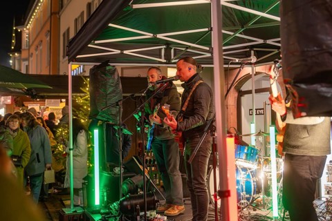 Live music performance on a stage in a festively illuminated market, Christmas market 2025, Nagold,