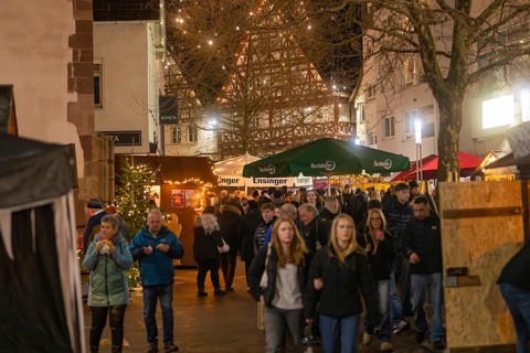 Lively Christmas market with numerous visitors and illuminated half-timbered houses, Christmas