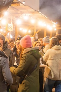 Sociable people in winter clothes at an atmospheric Christmas market, Christmas market 2025,