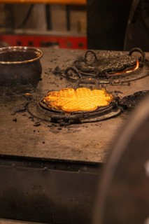 Freshly baked waffles on a hot iron in a Christmas setting, Christmas market 2025, Nagold, Black