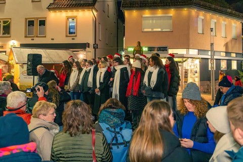 A choir sings on a busy street in front of an audience in wintry weather, Christmas market 2025,