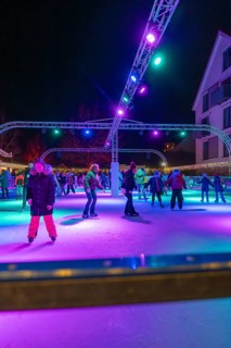 Night view of an ice rink with colorful lights, many people skating, Christmas market 2025, Nagold,