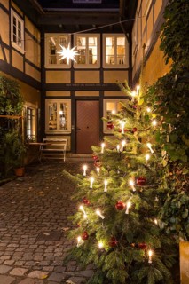 Decorated Christmas tree and Herrnhut star on a half-timbered house in the historic village center