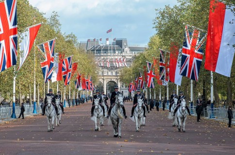 Mounted police with Union Jack flags on The Mall, behind the Admiralty Arch, Arc de Triomphe