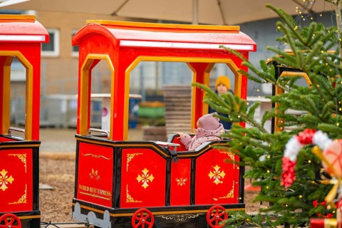 A child on a Christmassy decorated miniature train at a Christmas market, Sindelfingen, Böblingen