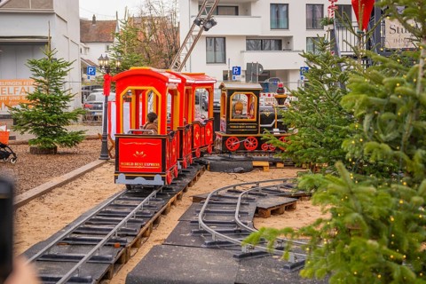 Children ride on a small toy train on tracks outside, Sindelfingen, Böblingen district, Germany