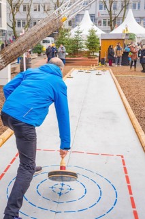 Man wearing a blue jacket playing curling on an outdoor course, Sindelfingen, Böblingen district,