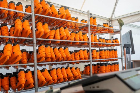 Shelves full of orange boots in a tent or storage room, Sindelfingen, Böblingen district, Germany