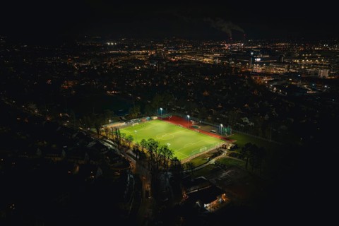 Football field at night with floodlights in urban landscape, Sindelfingen, Böblingen district,