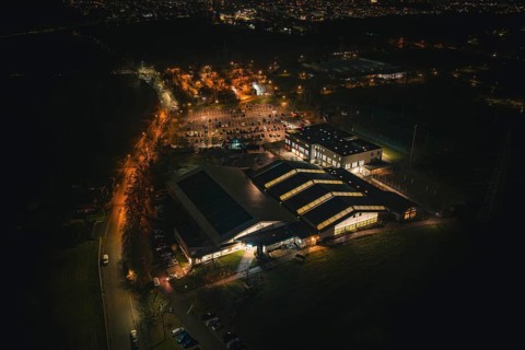 Night view of an illuminated building structure with surrounding parking spaces, Sindelfingen,