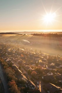 A village under golden sunlight with rays illuminating a warm autumn landscape, Gechingen, Hecken