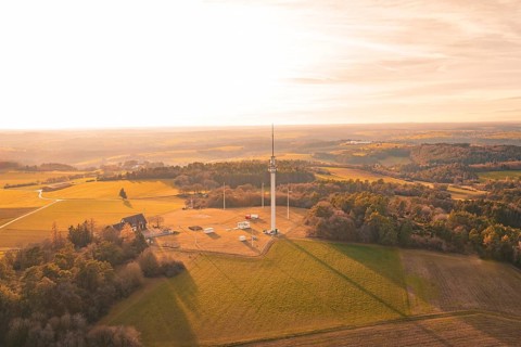Single radio tower in an open field surrounded by forests in the evening light, Gechingen, Hecken