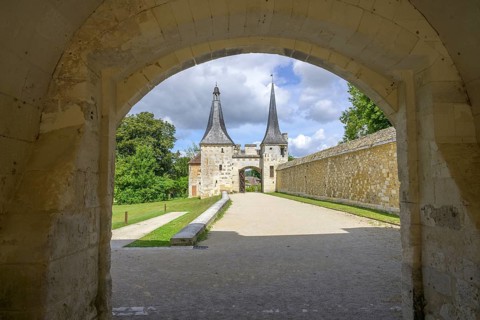View through archway to the double tower with entrance gate at the Abbey of, Le Bec-Hellouin, Eure,