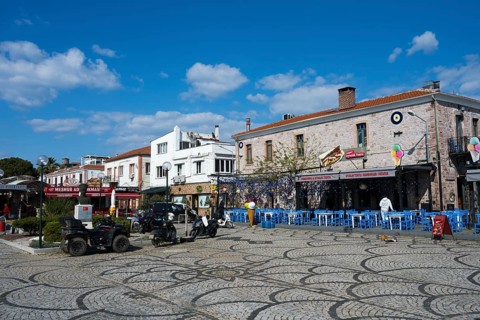 Colourful streetscape with historic buildings and cobblestones, cozy outdoor dining under blue