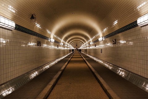 Pedestrians in the historic tunnel tube, Old Elbe Tunnel, symmetrically illuminated, tiled, Sankt