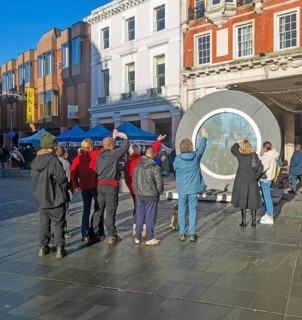 People on the Cornhill in the town centre view the first ever UK Portal in Ipswich, Suffolk,