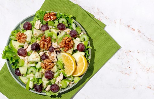 Fresh Waldorf salad, celery stalk with chicken, apple and walnuts, grapes, herbs, homemade, without