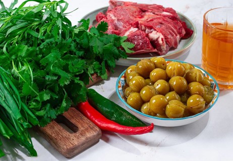 Ingredients for cooking chakapuli, canned tkemali, meat, herbs Georgian cuisine, top view