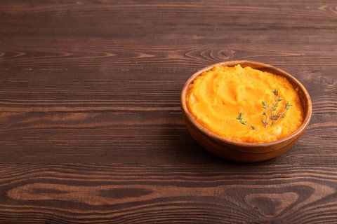 Sweet potato porridge in wooden bowl on wooden background. Diet, healthy eating concept. side view,