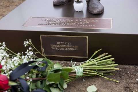 Red roses with a mourning ribbon lie in front of the Walter LÃ¼bcke memorial during the