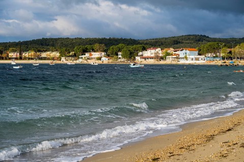 View of coast with soft waves, houses and cloudy sky, beach near GÃ¼zelyali, GÃ¼zelyalÄ±,