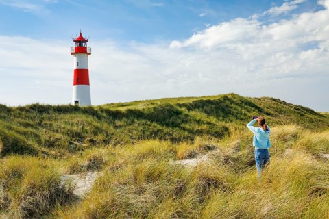 Young Fau takes a photo of the List-Ost lighthouse on his elbow on the island of Sylt, Germany