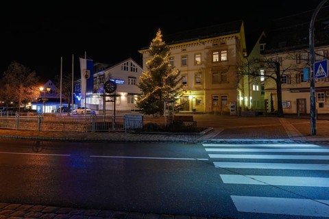 A festively lit Christmas tree on a side of the street at night, Aidlingen, Böblingen district,
