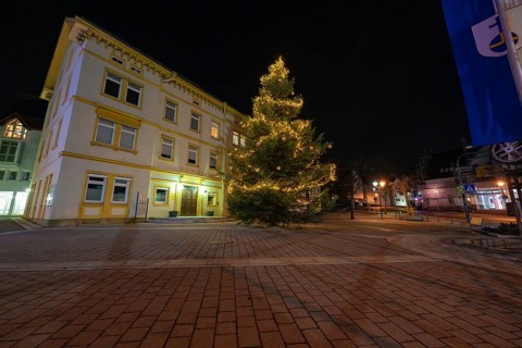 A brightly lit Christmas tree in front of a historic building at night, Aidlingen, Böblingen