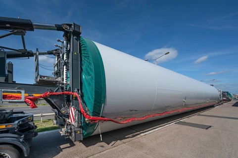 Overlong heavy-duty transporter with a part of a wind turbine, at a motorway rest area of the A9,