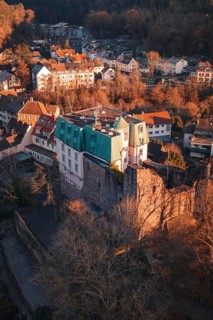 Picture of a castle and village in warm light with a view of wooded hills, Dillweisenstein,