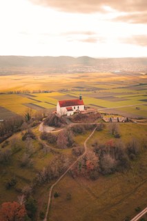 Church on a hill with extensive views of fields and forests in warm light, Wurmlinger Chapel,