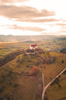 A hill with a church surrounded by vast fields under a dramatic sky, Wurmlinger Chapel, Rottenburg