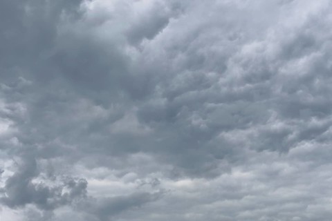 Grey cloud cover from Stratocumulus with bump-like bulges at the bottom unevenly marked by dents,