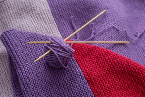 Purple and red knit with balls of wool and needles, North Rhine-Westphalia, Germany
